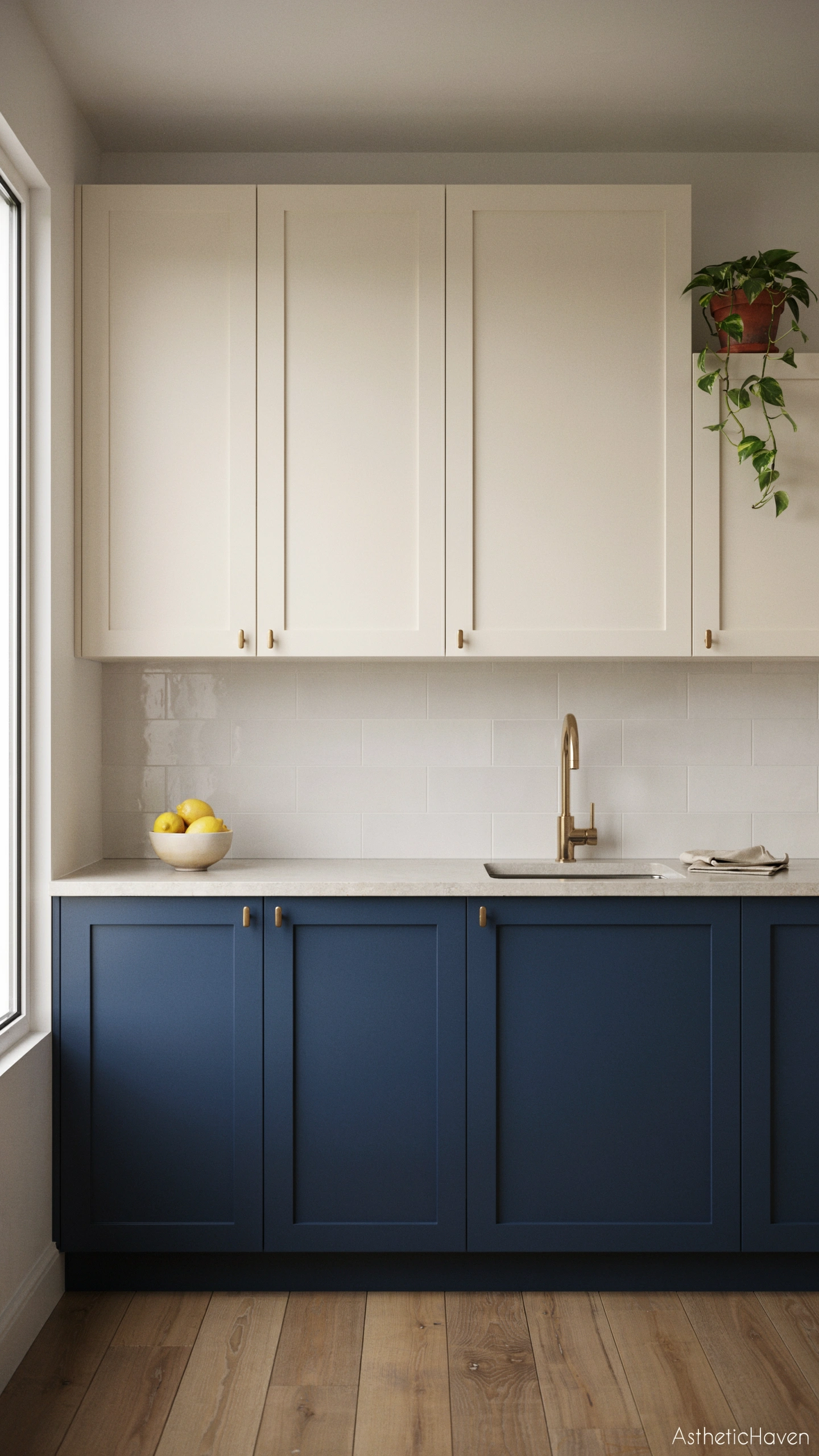 Realistic contemporary kitchen featuring elegant two-tone cabinetry, deep navy lower cabinets paired with warm cream upper cabinets, pale stone worktops, subtle brass hardware, balanced natural daylight, clean modern backsplash, polished wooden flooring, strong focus on the contrasting cabinet colours, uncluttered surfaces, no people, refined editorial interior photography, Pinterest and blog-friendly framing, vertical 2:3 aspect ratio, high-quality realistic detail, no text overlay, small subtle “AstheticHaven” watermark in the bottom corner.